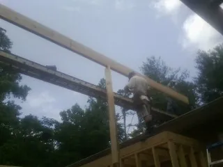 Carpenter setting a ridge beam over a new addition frame — Ice Dam Removal by Roofing Brothers in Simla