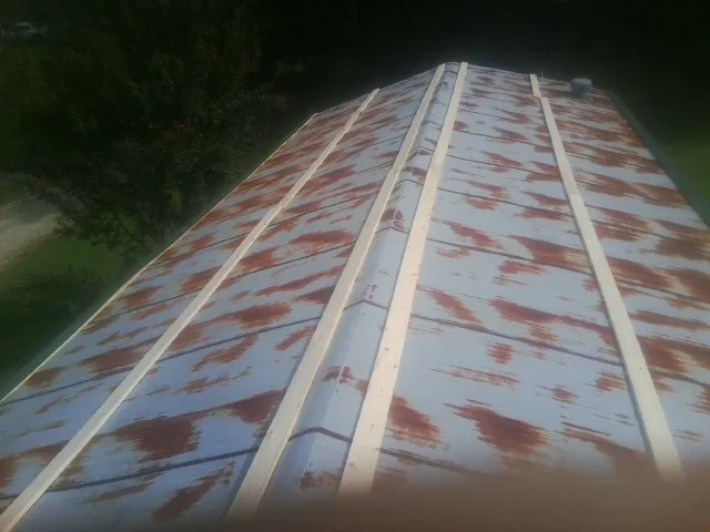 Rusted metal roof panels with new wood purlins before replacement — Storm Damage Roof Repair in Simla by Roofing Brothers