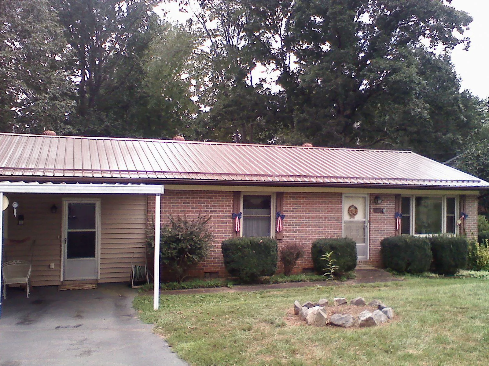 Bronze metal roof and carport on a brick ranch home — Roof Repair work by our crew in Simla